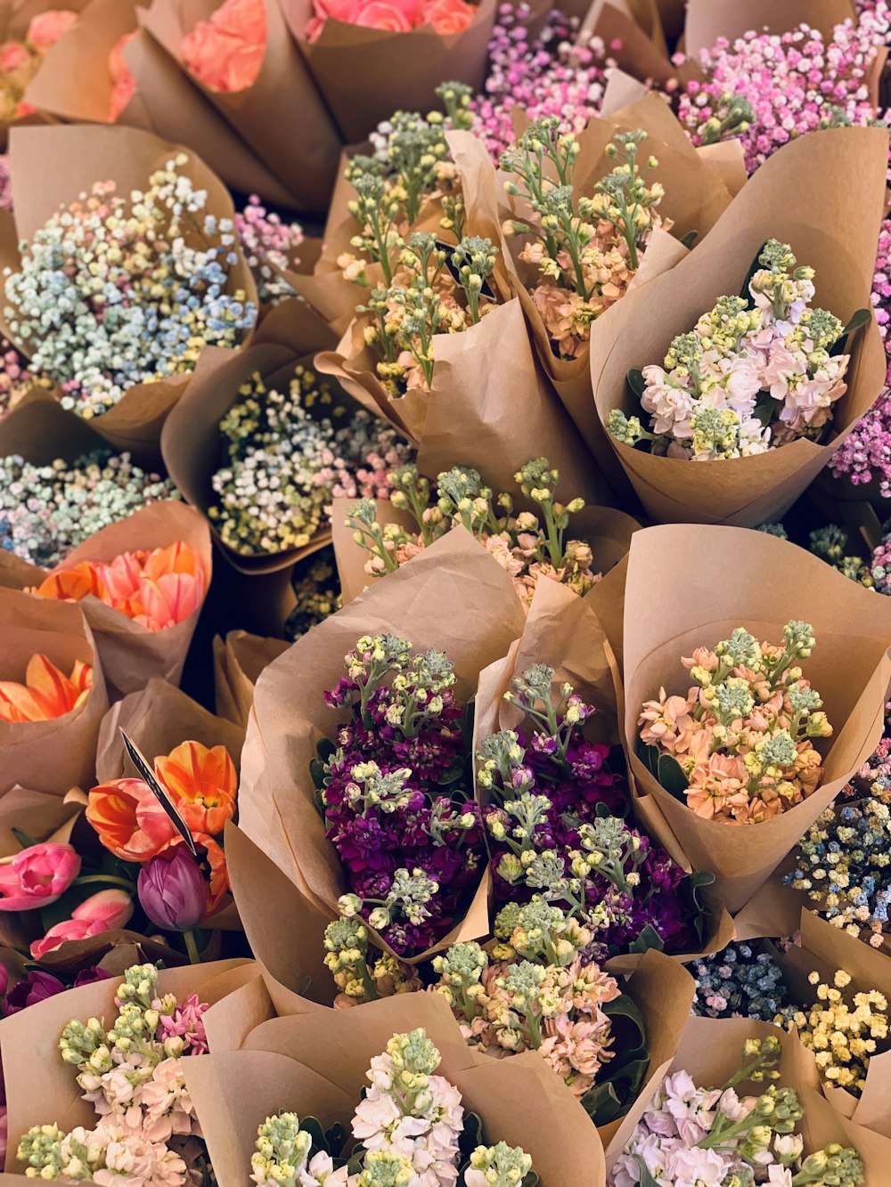 Ramos de temporada envueltos a mano en papel kraft en el mostrador de la floristería