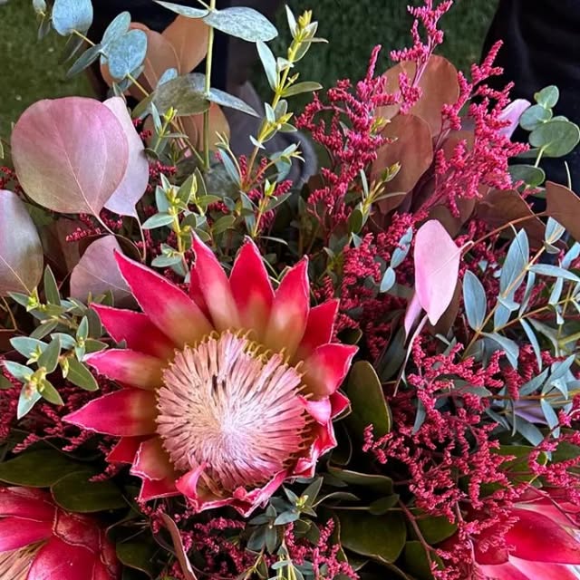 Ramo de protea y flores secas en tonos rosa y burdeos con eucalipto